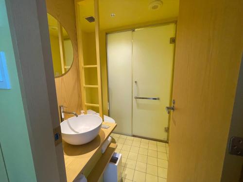 a bathroom with a toilet and a sink and a shower at toggle hotel suidobashi TOKYO in Tokyo