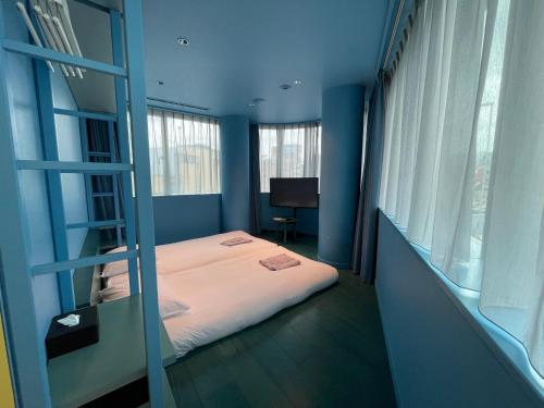 a bedroom with a bunk bed in a blue room at toggle hotel suidobashi TOKYO in Tokyo