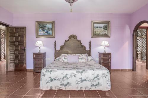 una camera da letto con un letto grande e due comodini di Cortijo La Dehesa del Pilar a Setenil