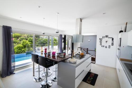 a kitchen with white appliances and a large window at Villa Angel Sunset in Gustavia