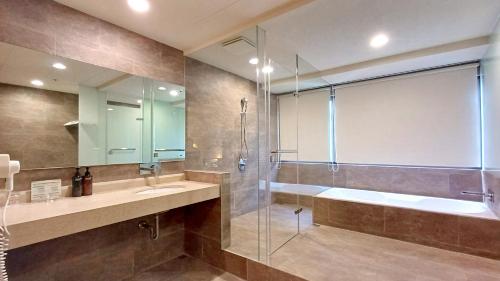 a bathroom with a shower and a tub and a sink at Hi-YES HOTEL TAOYUAN in Zhongli