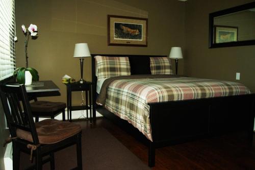 a bedroom with a bed with a desk and a chair at Stardust Inn and Chalets in Pincher Creek