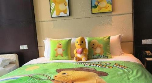 three stuffed animals sitting on top of a bed at Suzhou Qingshan Conference Center in Suzhou