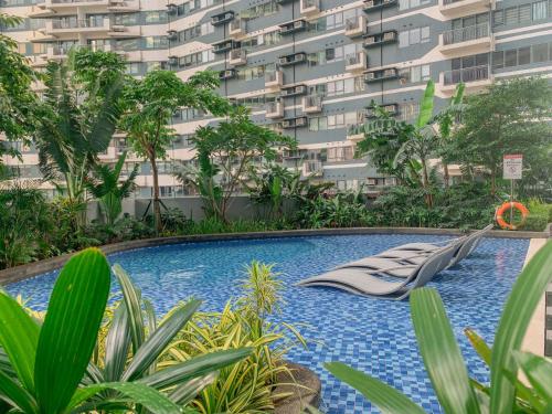 a swimming pool in front of a large building at Makati 1BR with Skyline View at Air Residences in Manila