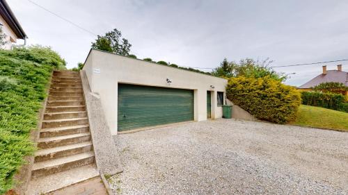 a garage with a green garage door and stairs at Fáy Mansion in Irota