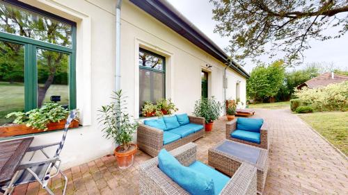 a patio with blue couches and chairs on a house at Fáy Mansion in Irota