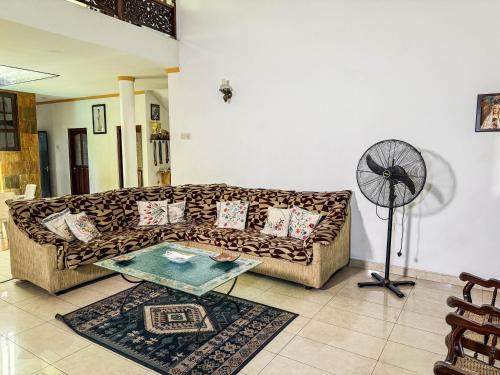 a living room with a couch and a fan at Gondolas Home Stay in Ragama