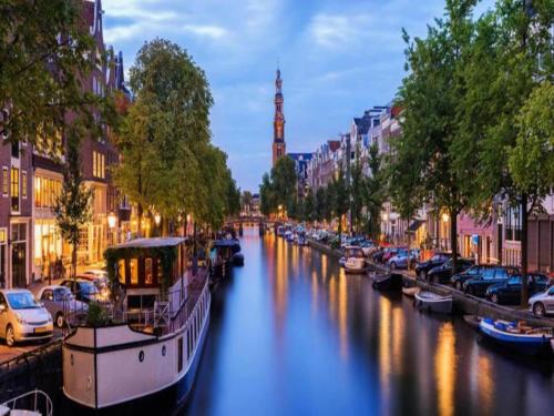 a river with boats in a city at night at Houseboat in Volendam near Fort Edam in Volendam