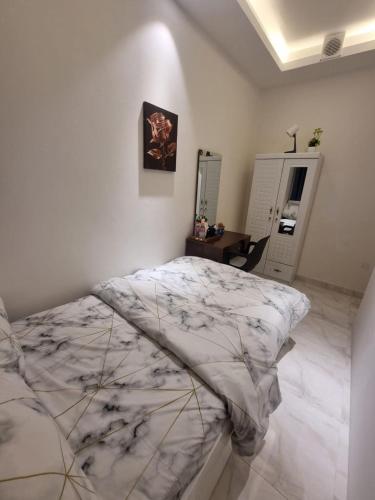a bedroom with a bed and a desk and a mirror at Emira Property in Abu Dhabi