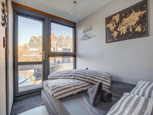 a bedroom with a bed and a large window at Houseboat in Volendam near Fort Edam in Volendam
