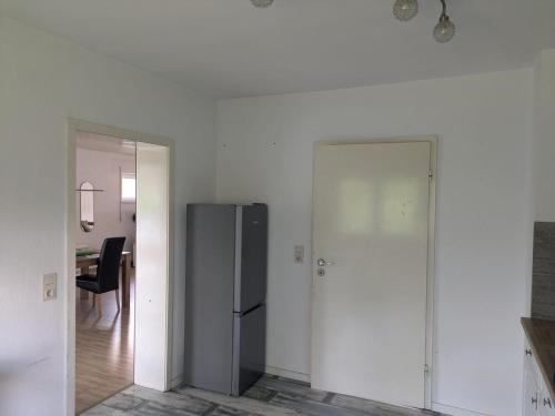a white room with a refrigerator and a hallway at Spacious and Luminous Apartment in a Bungalow in Züsch