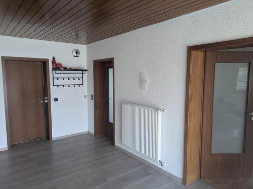 an empty room with two doors and wooden floors at Spacious and Luminous Apartment in a Bungalow in Züsch