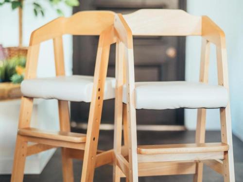 two wooden chairs sitting next to each other at Hotel Areaone Miyazaki in Miyazaki