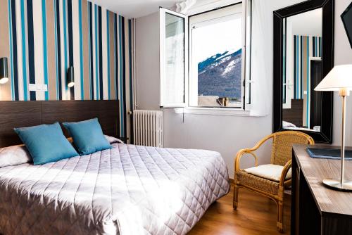 een slaapkamer met een bed, een bureau en een raam bij Hôtel Panoramic in Luchon