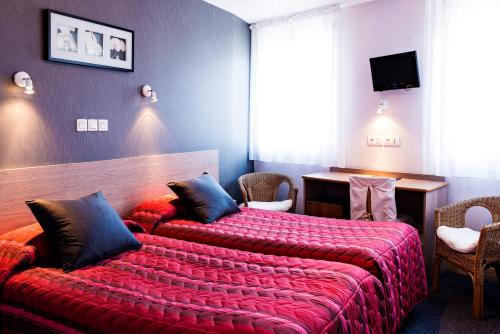 a bedroom with a large bed with a red blanket at Hôtel Panoramic in Luchon