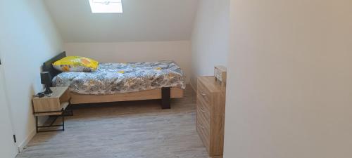 Un dormitorio pequeño con una cama y una cómoda. en Chez MaLouNa - 15 min de la Baie de Somme, en Friville-Escarbotin