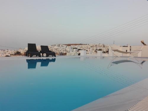 a large swimming pool with chairs and buildings in the background at Villa Irini in Naousa