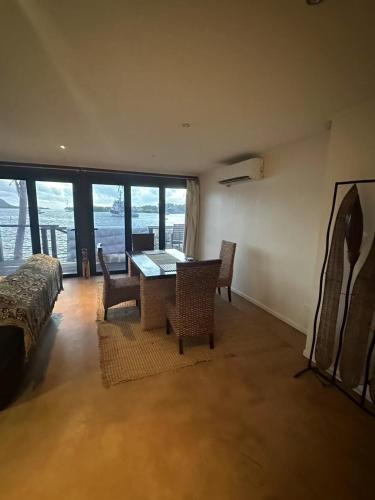 a dining room with a table and chairs in a room with windows at Blue Marlin Lodge in Port Vila