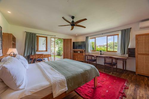 a bedroom with a bed and a desk and a ceiling fan at Villa Rice - Amazing Rice-Field VIEW 3BR Villa 9px Next To Canggu in Kerobokan
