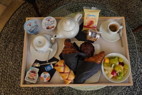a tray of food with bread and a cup of coffee at Palazzo Conti Camere & Suites in Scicli