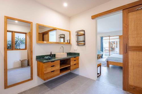 a bathroom with a sink and a mirror at Villa Rice - Amazing Rice-Field VIEW 3BR Villa 9px Next To Canggu in Kerobokan