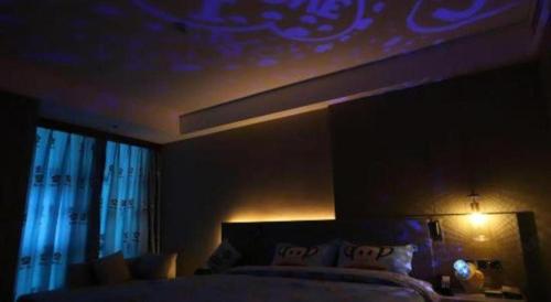 a dark bedroom with a bed with a light on it at Empark Grand Hotel Fuzhou in Fuzhou