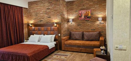 a bedroom with a bed and a chair at AMARCORD BOUTIQUE HOTEL in Tbilisi City