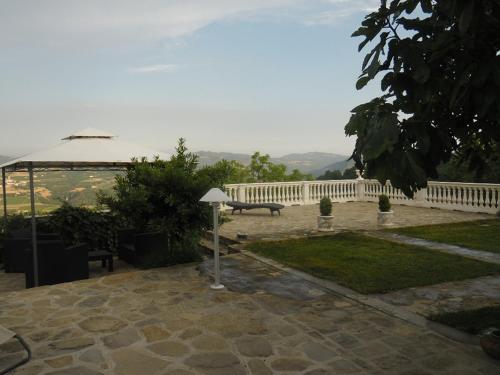 eine Terrasse mit einem weißen Zaun und einer Bank in der Unterkunft Eremo Pace e Gioia in Castino