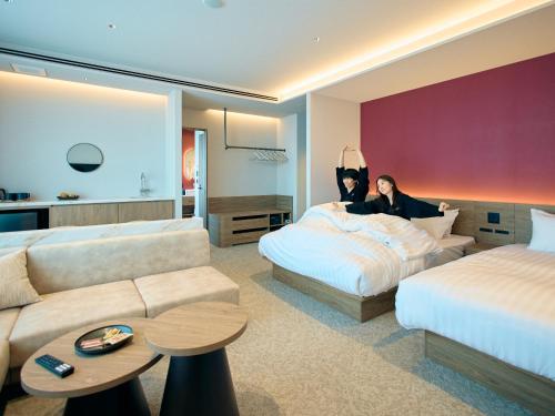 a hotel room with two people laying on a bed at FAV LUX Sapporo Susukino in Sapporo