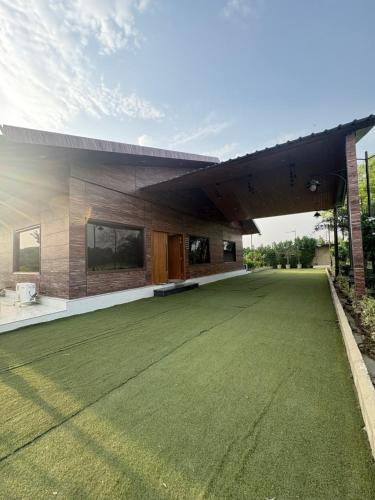 a house with a green lawn in front of it at 4BHK Greenwood Farm And Lawn -Bijwasan I Delhi-Gurgaon Border I 87oo2o5865 in Gurgaon