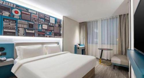 a hotel room with a bed and a wall with signs at 7 Days Inn Baoding Railway Station in Baoding