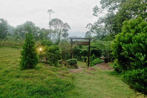 a garden with a gate in the middle of a field at Harmony Valley Retreat in Bukit Tinggi
