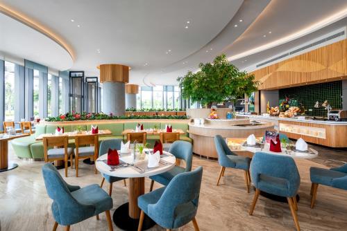 a restaurant with tables and chairs and a cafeteria at OceanView Alacarte Hạ Long in Ha Long