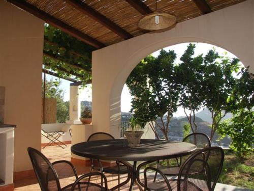 a table and chairs on a patio with an archway at Villa Hermes Case Vacanza in Lipari