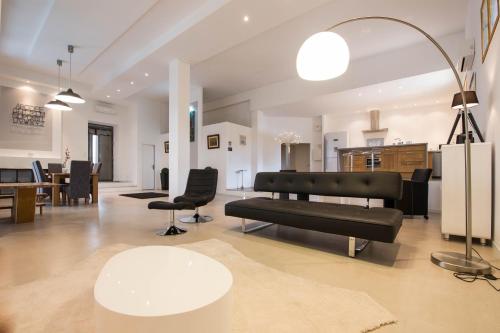 a living room with a black couch and a table at l'Ecrit Vin in Rustiques