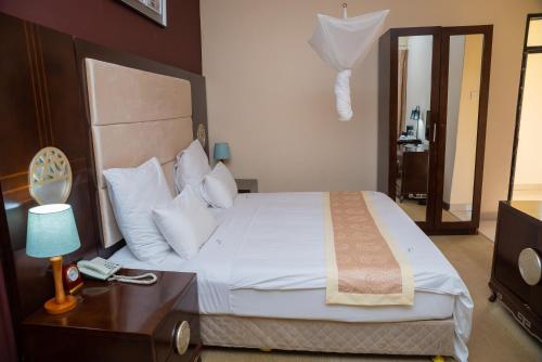 a bedroom with a bed and a table with a lamp at Hapuwani Village Lodge in Mulanje