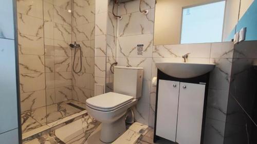 a bathroom with a toilet and a sink at Domki Bosman in Dziwnówek