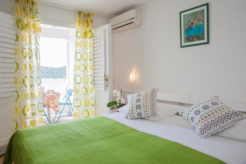 a bedroom with a bed and a window with a chair at Hana Home - Apartments Tisno in Tisno