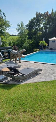 a statue of a dinosaur next to a swimming pool at Waldzauber Appartement in Horhausen