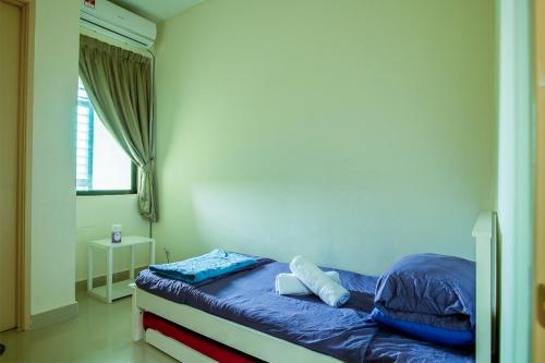 a bedroom with a bed with blue sheets and a window at Spacious 4BR Double Storey Home Balik Pulau in Balik Pulau