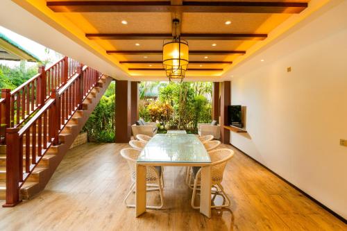 a dining room with a glass table and chairs at H Resort Bohol - The Coral Cliff by SMS Hospitality in Calape