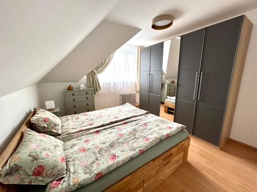 ein Schlafzimmer mit einem Bett mit geblümter Tagesdecke in der Unterkunft Ágica Nyaraló in Balatonkenese