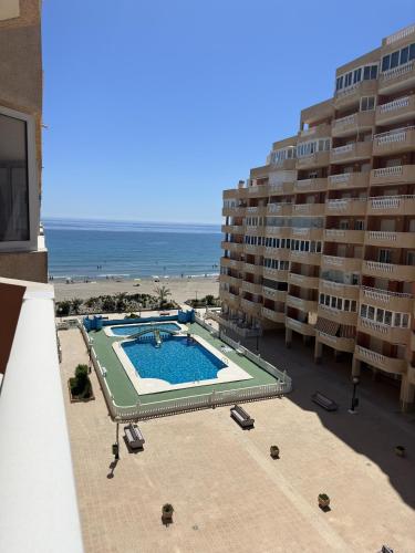 a view of a swimming pool next to a beach at Hawaii V 25B - La Manga By WATERMELON in La Manga del Mar Menor