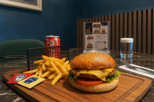 a hamburger and french fries on a wooden tray at AXU AIRPORT HOTEL in Arnavutköy