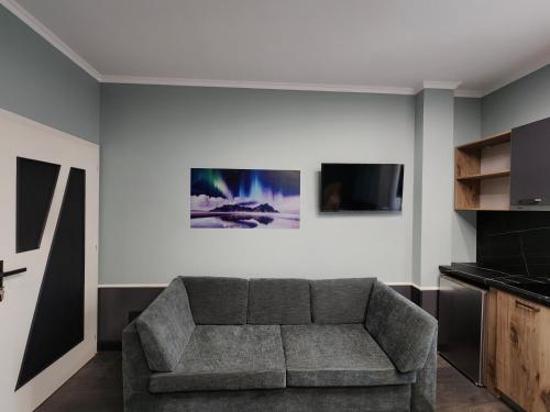 Una sala de estar con un sofá y un televisor en Aura Hotel, en Durrës