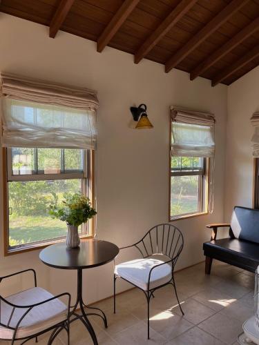 a living room with a table and chairs and windows at House tomari木-山梨 in Yamanashi