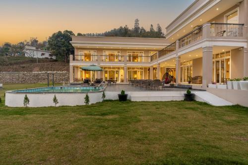 a large house with a pool in the yard at SaffronStays Sukh Saklana Haveli Suites in Rishīkesh