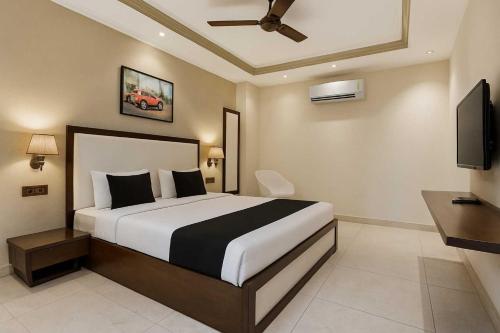 a bedroom with a bed and a flat screen tv at Collection O Udyog Vihar in Gurgaon