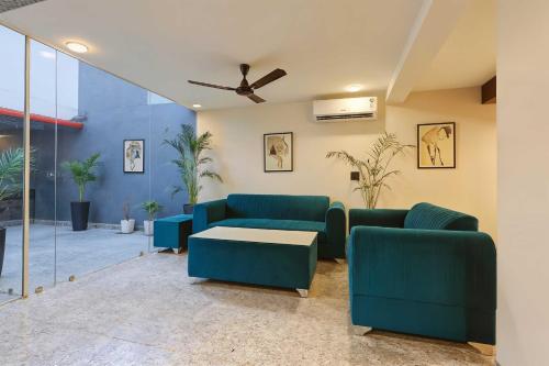 a living room with blue couches and a table at Collection O Udyog Vihar in Gurgaon