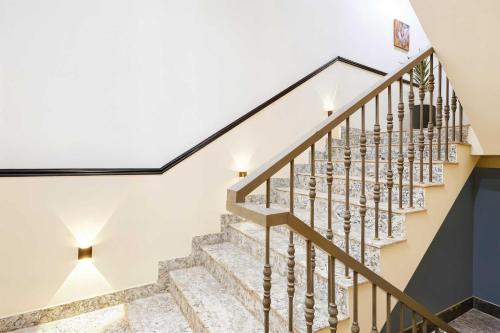 a staircase in a house with white walls and a glass ceiling at Collection O Udyog Vihar in Gurgaon